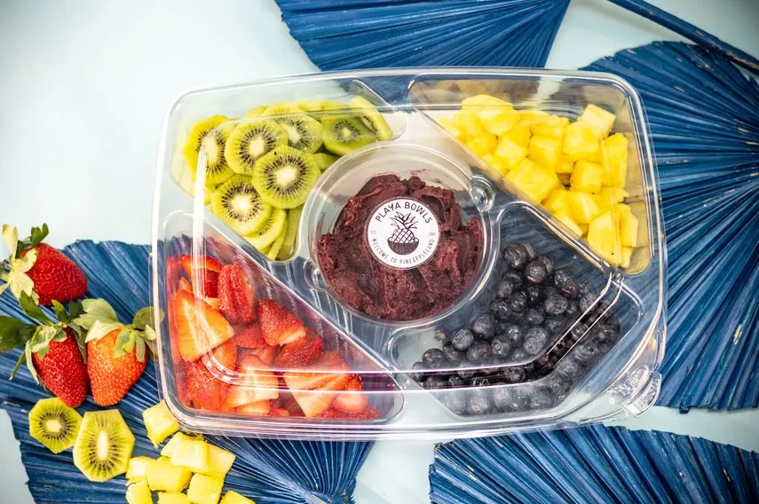 Fruit tray with kiwi, pineapple, strawberries, blueberries and an açaí dip